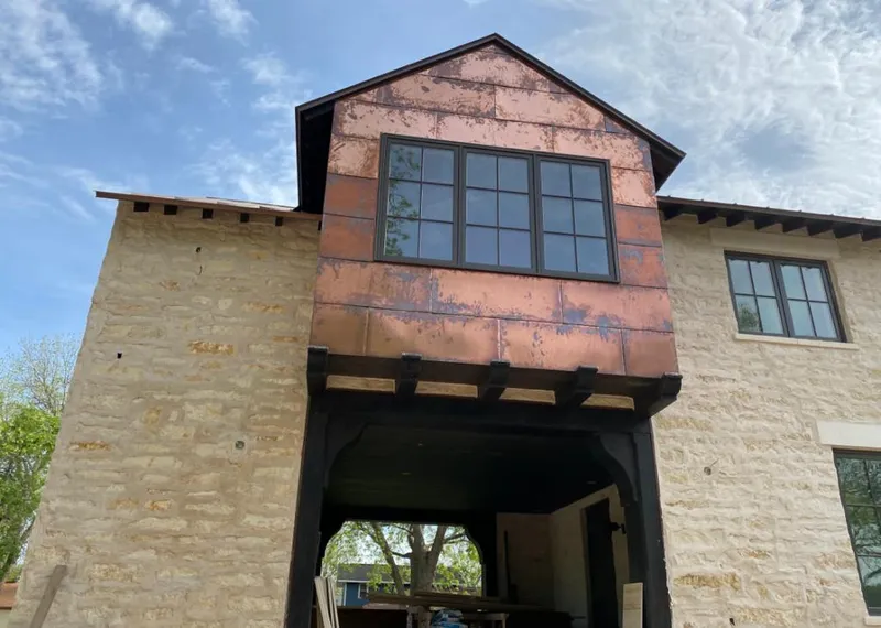 Copper metal panel facade on a stone building for Metal Roof Coating in Anamosa