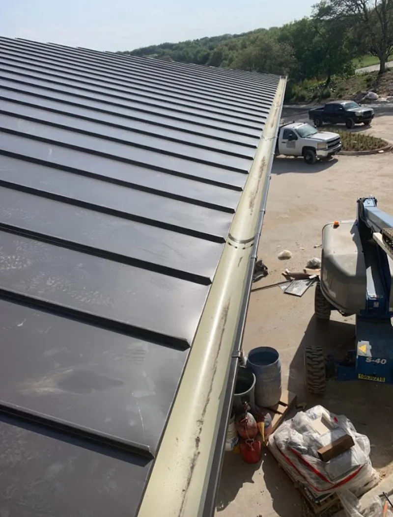 Standing seam panel and gutter detail on a metal roofing jobsite in Anamosa